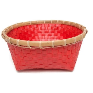 Op de afbeelding: Een rode geweven mand met een natuurlijke bamboe rand. De mand heeft een rechthoekige vorm met afgeronde hoeken. Het weefpatroon is zichtbaar en de mand is leeg. De rand is gemaakt van lichtbruin bamboe.