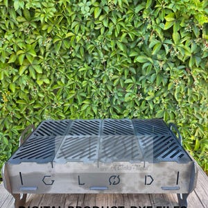 Puede incluir: Una taza de cerámica blanca con un asa negra y el texto "But First, Coffee" en negro y negrita. La taza está sobre una superficie de madera. La taza mide aproximadamente 10 cm de alto.