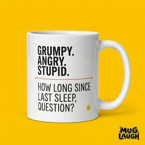 Puede incluir: Taza de cerámica blanca con las palabras "GRUMPY. ANGRY. STUPID." encima de una línea, y "HOW LONG SINCE LAST SLEEP, QUESTION?" debajo. Un pequeño icono de taza de café está a la derecha. La taza tiene un asa curva.