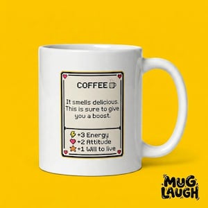 Puede incluir: Taza de café de cerámica blanca con un gráfico en blanco y negro que dice "COFFEE". El gráfico incluye el texto "It smells delicious. This is sure to give you a boost." y estadísticas de energía, actitud y ganas de vivir. La taza tiene un asa grande.
