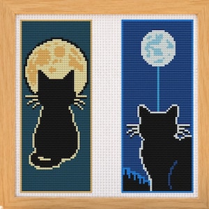 Puede incluir: Un bordado en punto de cruz enmarcado con dos paneles verticales. El panel izquierdo muestra la silueta de un gato negro frente a una gran luna amarilla sobre fondo azul oscuro. El panel derecho muestra un gato negro mirando hacia una luna azul.