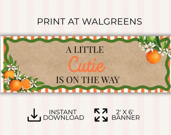 以下が含まれることがあります： オレンジ色のスクリプトで「A Little Cutie Is On The Way」と書かれたバナー。バナーはオレンジ、白い花、緑の葉で飾られています。バナーのサイズは61cm×183cmです。
