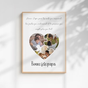 May include: A framed print with a light wood frame. The print features a heart-shaped collage of family photos. The text "Merci Papa, pour tes mots qui rassurent...Bonne fete papa" is written in black script.