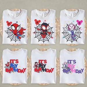 Op de afbeelding: Witte T-shirts met Spider-Man-personages op een web, elk met een nummer 4 ballon. De onderste rij shirts leest "IT'S MY BIRTHDAY" in rood, blauw en roze. De shirts worden gepresenteerd op geweven matten.
