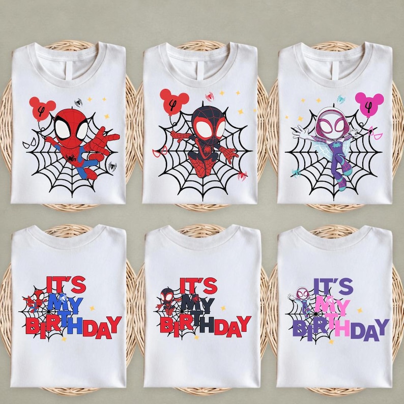 Op de afbeelding: Witte T-shirts met Spider-Man-personages op een web, elk met een nummer 4 ballon. De onderste rij shirts leest "IT'S MY BIRTHDAY" in rood, blauw en roze. De shirts worden gepresenteerd op geweven matten.