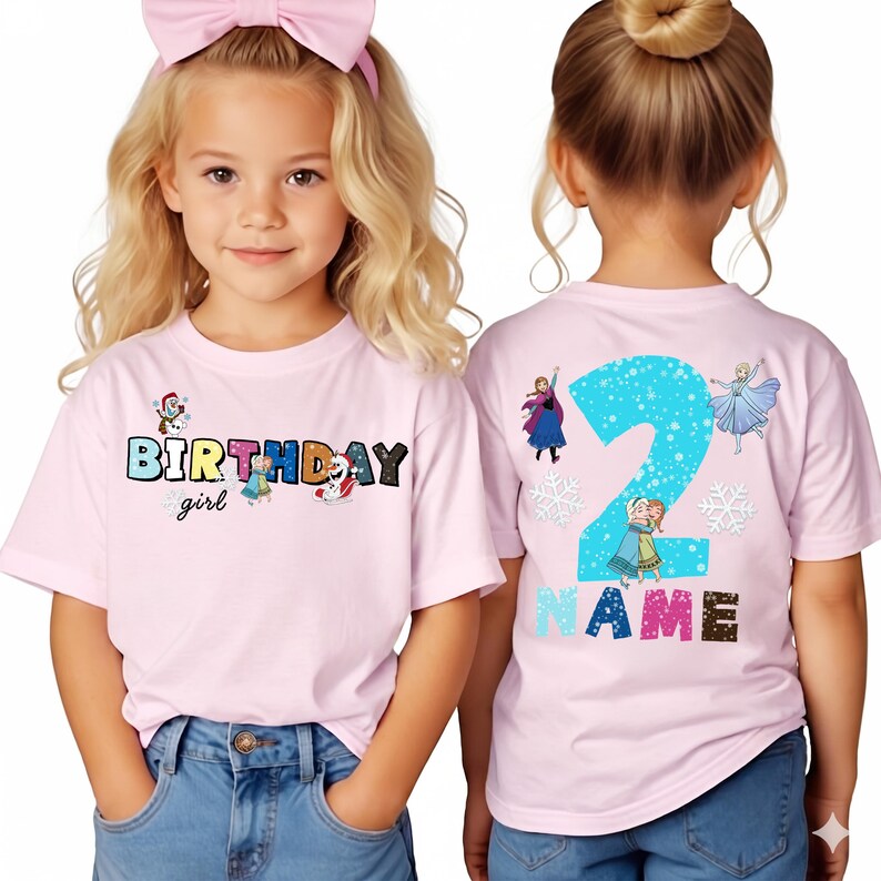 Op de afbeelding: Roze T-shirts met korte mouwen met een kleurrijke "BIRTHDAY girl" afbeelding op de voorkant en een groot nummer "2" op de achterkant. De shirts hebben cartoonfiguren en sneeuwvlokken, perfect voor een verjaardag.
