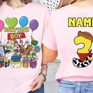 Op de afbeelding: Roze T-shirt met een Toy Story-ontwerp. De voorkant toont personages, ballonnen en "BIRTHDAY BOY". De achterkant heeft een nummer 3 met een cowboyhoed en bandana, en het woord "NAME" in geel.