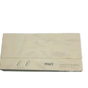 May include: A rectangular, off-white electronic accessory with a smooth surface. It features two oval buttons labeled mem + and memory, along with the printed text PFAFF creative designer Made by Pfaff in West Germany on the front panel.
