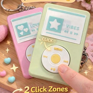 Può includere: Portachiavi clicker rosa e verde a forma di lettori musicali retrò. Il portachiavi rosa ha uno schermo con cuori e la parola "LOVE". Il portachiavi verde ha uno schermo con una stella e la parola "VIBES".
