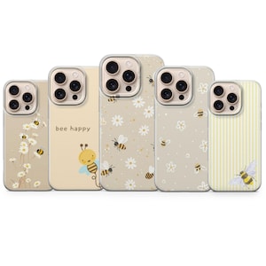 Könnte beinhalten: Fünf Smartphone-Hüllen mit Bienen- und Gänseblümchen-Motiven. Eine Hülle ist hellgelb mit einer Biene und dem Text "bee happy". Andere zeigen Gänseblümchenmuster mit Bienen oder gelb-weiße Streifen mit einer einzelnen Bienenillustration.