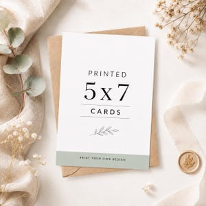 May include: A white rectangular card with the black text PRINTED 5x7 CARDS, a thin horizontal line, and a small leaf illustration. The bottom features a sage green band with the text PRINT YOUR OWN DESIGN in black, centered on a brown envelope.