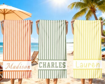 Könnte beinhalten: Drei Strandtücher mit vertikalen Streifen in Orange, Grün und Gelb. Jedes Handtuch hat ein weißes Band mit einem Namen: "Madison", "Charles" und "Lauren". Die Handtücher werden an einem sonnigen Strand mit Sonnenschirm und Palmen hochgehalten.