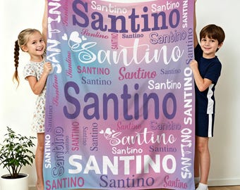 Könnte beinhalten: Eine personalisierte Decke mit dem Namen "Santino" in verschiedenen Größen und Schriftarten, vor einem Hintergrund aus Rosa, Lila und Blau. Die Decke wird von zwei Kindern gehalten.