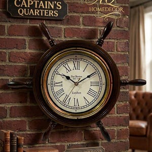 Puede incluir: Un reloj de pared decorativo diseñado como un timón de barco, montado en una pared de ladrillo. La esfera del reloj tiene números romanos y el texto "London". El reloj es marrón con detalles dorados y tiene cuatro radios. El letrero de arriba dice "The Captain's Quarters".