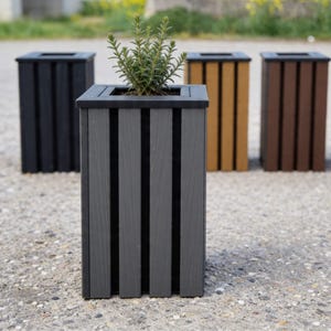 May include: Four wooden planters in varying shades of gray, black, brown, and tan. The front planter is gray and contains a small green plant. Each planter has vertical slats and a square top.