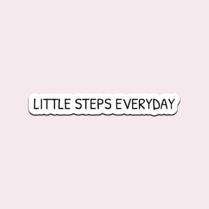 May include: A white sticker with the phrase "LITTLE STEPS EVERYDAY" in black, sans-serif font. The sticker has a white border and is set against a light pink background. The text is centered horizontally.