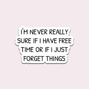 Op de afbeelding: Een witte sticker met een zwarte rand en de tekst "I'M NEVER REALLY SURE IF I HAVE FREE TIME OR IF I JUST FORGET THINGS" in een handschriftachtig lettertype. De sticker staat op een lichtroze achtergrond.