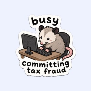 Może przedstawiać: Naklejka przedstawiająca kreskówkowego oposa siedzącego przy biurku i piszącego na komputerze. Tekst nad opossem brzmi "busy", a pod nim "committing tax fraud". Opos jest szary i biały z różowym ogonem.