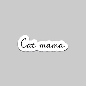 以下が含まれることがあります： 黒い筆記体で「Cat mama」と書かれた白いステッカー。ステッカーは白い縁取りがあり、灰色の背景に配置されています。テキストは手書き風です。