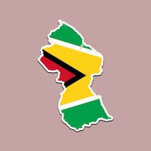 May include: A sticker in the shape of Guyana, featuring the country's flag design. The flag has green, yellow, red, black, and white colors. The sticker has a white border and is set against a muted pink background.