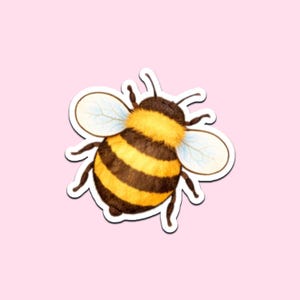 Könnte beinhalten: Ein Aufkleber mit einer detaillierten Illustration einer Hummel. Die Biene hat einen flauschigen, gelb-schwarz gestreiften Körper, zarte Flügel und kleine Fühler. Der Aufkleber befindet sich auf einem hellrosa Hintergrund.