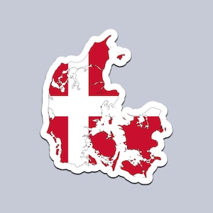 Könnte beinhalten: Ein Aufkleber mit der Karte Dänemarks im Design der dänischen Flagge. Die Karte ist rot mit einem weißen skandinavischen Kreuz, weiß umrandet, vor grauem Hintergrund. Der Aufkleber hat einen weißen Rand.
