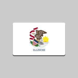 Op de afbeelding: Rechthoekige witte magneet met het zegel van de staat Illinois. Het zegel bevat een bruine adelaar, een schild met een rood-wit gestreept patroon en het woord "ILLINOIS" in blauw.