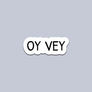 May include: A white sticker featuring the words "OY VEY" in a black, sans-serif font. The sticker has a rounded, cloud-like border and is set against a light grey background. The text is centered.