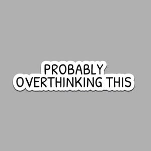 May include: A white sticker with the phrase "PROBABLY OVERTHINKING THIS" in black, sans-serif font. The sticker has a rounded rectangular shape and is set against a gray background.