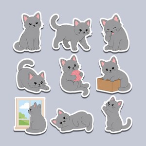 May include: A collection of nine die-cut stickers featuring a gray kitten in various poses, including sitting, walking, grooming, playing with a pink ball of yarn, sitting in a brown box, looking out a window, lying down, and standing on hind legs.