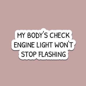 Może przedstawiać: Biała naklejka z czarnym tekstem: „MY BODY'S CHECK ENGINE LIGHT WON'T STOP FLASHING” na tle brudnego różu. Naklejka ma białą obwódkę.