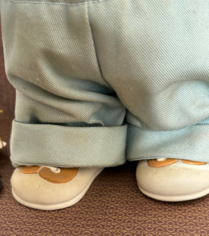 Puede incluir: Un par de pantalones azul claro con los pu&ntilde;os enrollados. Los pantalones son usados por una mu&ntilde;eca con zapatos marrones.