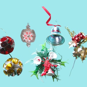 Pode incluir: Uma coleção de enfeites de Natal vintage em várias formas e cores. Inclui um sino prateado com uma fita vermelha, um grupo vermelho e dourado e vários enfeites redondos e geométricos com detalhes vermelhos, dourados e prateados. Decoração festiva de férias.