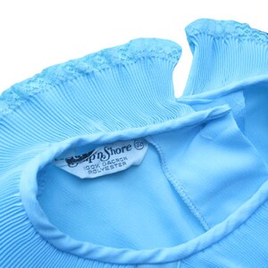 K&ouml;nnte beinhalten: Ein Set aus drei Keramikbechern mit cremefarbener, gesprenkelter Glasur. Jeder Becher zeigt ein handgemaltes Blumendesign in Blau-, Gr&uuml;n- und Gelbt&ouml;nen. Die Becher haben eine schlichte, runde Form und einen bequemen Henkel.