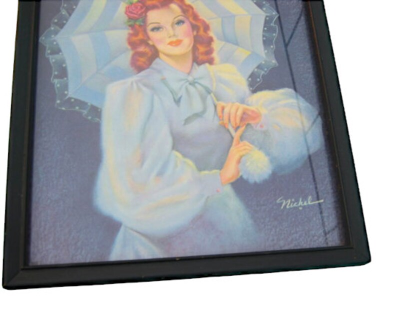 Op de afbeelding: Een ingelijste vintage illustratie van een vrouw met rood haar die een witte jurk draagt en een wit-blauwe gestreepte parasol vasthoudt. De vrouw glimlacht en kijkt naar de kijker. De illustratie is rechtsonder getekend met "Nickel".
