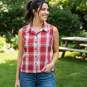 May include: A sleeveless red and white plaid shirt with a collared neckline and button-down front. The shirt is paired with blue jeans. The shirt has adjustable ties on the sides.