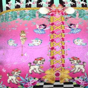 May include: A pink and green patterned pillow with a checkered design at the bottom. The pillow features a whimsical design with a central yellow rope ladder, white lambs, and a pink and blue teacup.