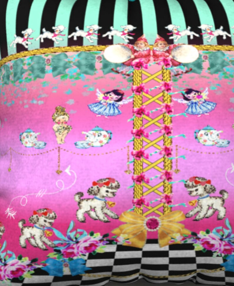May include: A pink and green patterned pillow with a checkered design at the bottom. The pillow features a whimsical design with a central yellow rope ladder, white lambs, and a pink and blue teacup.