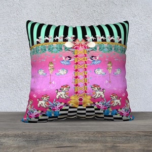 May include: A pink and green decorative pillow with a black and white checkered pattern at the bottom. The pillow features a whimsical design with a central column of flowers and a series of small dolls and dogs.