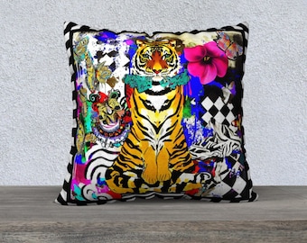 May include: A square throw pillow featuring a central tiger illustration with a teal neck ruffle, surrounded by vibrant abstract patterns, butterflies, a bright pink flower, and a black and white checkered border on the edges.