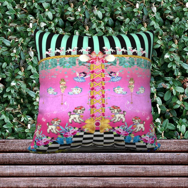 May include: A pink and green throw pillow with a whimsical design featuring dancing dolls, dogs, and a checkered pattern.