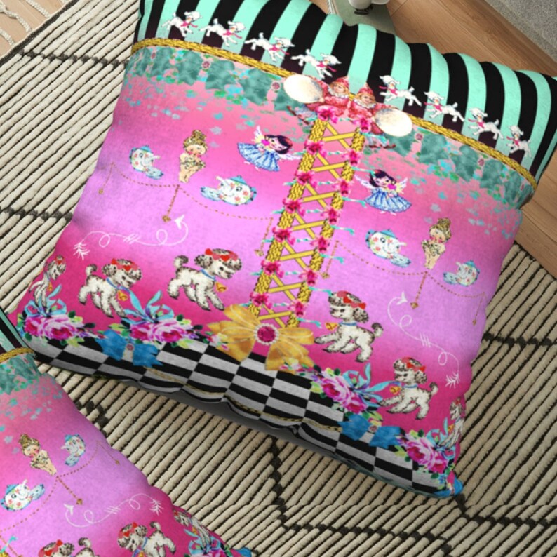May include: A pink and green throw pillow with a whimsical design featuring a carousel with dolls, poodles, and teacups. The pillow has a black and white checkered border.