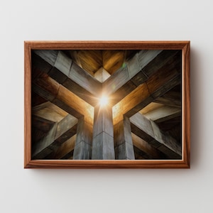 Può includere: Fotografia incorniciata di una struttura architettonica con un design geometrico. L'immagine mostra travi di legno e pilastri di cemento che si intersecano, con una fonte di luce brillante al centro. La cornice è in legno scuro.