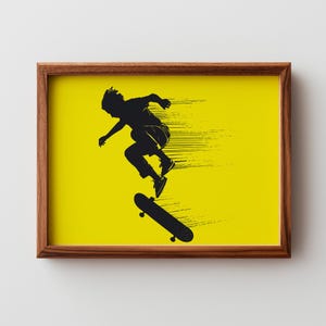 Puede incluir: Impresión artística enmarcada que presenta una silueta negra de un skater en pleno salto sobre un fondo amarillo brillante. La obra de arte está encerrada en un marco de madera marrón. El skater está realizando un truco.