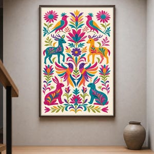 Puede incluir: Una lámina de arte mural rectangular en un marco oscuro con un diseño de arte popular simétrico y colorido sobre un fondo crema. La ilustración muestra aves, ciervos y conejos vibrantes rodeados de flores y hojas estilizadas en tonos rosa, azul, amarillo y naranja.