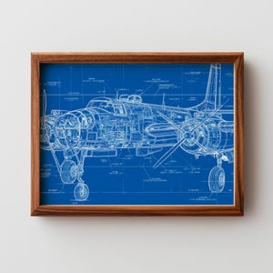 May include: A framed blueprint of a vintage airplane, showcasing detailed internal components and external features. The artwork is rendered in white lines against a vibrant blue background, encased in a brown wooden frame.