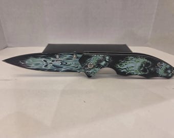 Navaja plegable con bloqueo Linerlock y diseño de calavera con llamas y apertura asistida Snake Eye (nueva).
