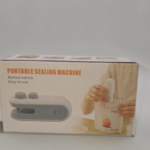 May include: A white and gray portable sealing machine with the text "PORTABLE SEALING MACHINE" on the box. The box also shows a person using the machine to seal a bag of dried peaches.