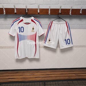 Puede incluir: Un conjunto de f&uacute;tbol blanco que incluye una camiseta y pantalones cortos con detalles en azul y rojo. La camiseta muestra el n&uacute;mero 10 en azul, un emblema de gallo y el texto TopsForYouCo. El pantal&oacute;n corto tambi&eacute;n tiene el n&uacute;mero 10 y un gallo.