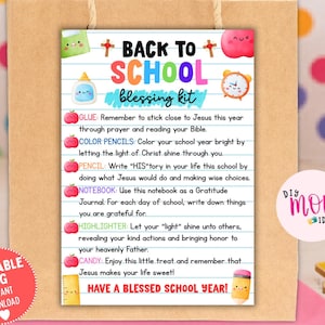 Puede incluir: Una bolsa de regalo de papel marrón con una etiqueta rectangular con el texto BACK TO SCHOOL blessing kit. La etiqueta incluye ilustraciones de material escolar, manzanas y cruces, con instrucciones impresas para diversos artículos.